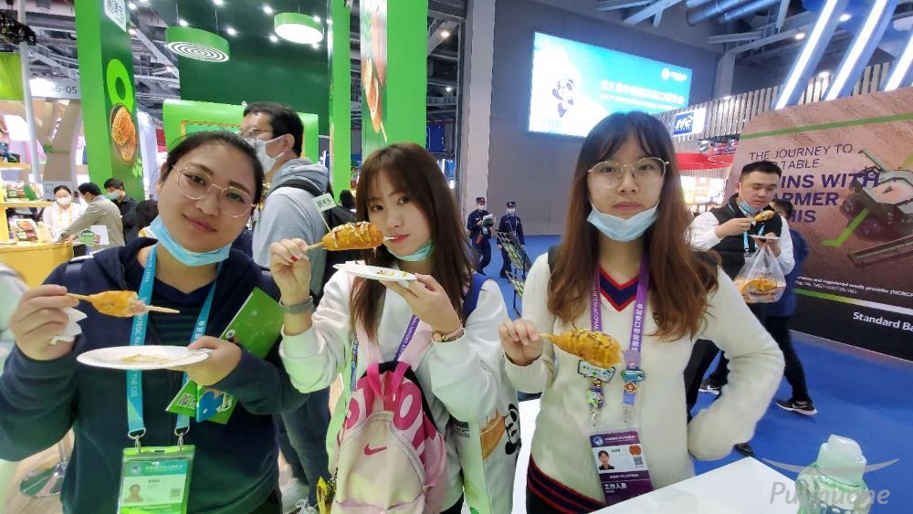 [사진3] 풀무원 홍보관 관람객들이 SNS 이벤트에 참여하고 받은 모짜렐라 핫도그를 시식하고 있다..jpg